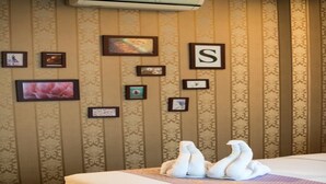 A hotel room with a bed, wall-mounted air conditioning unit, and framed pictures on the wall. - Sunday J Resort & Restaurant (Chonburi)