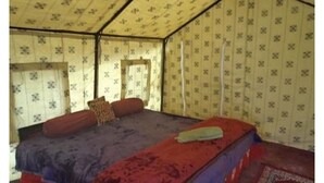 A tent-style room with a single bed, a window, and patterned walls. - Golden Mark Camp (Leh)