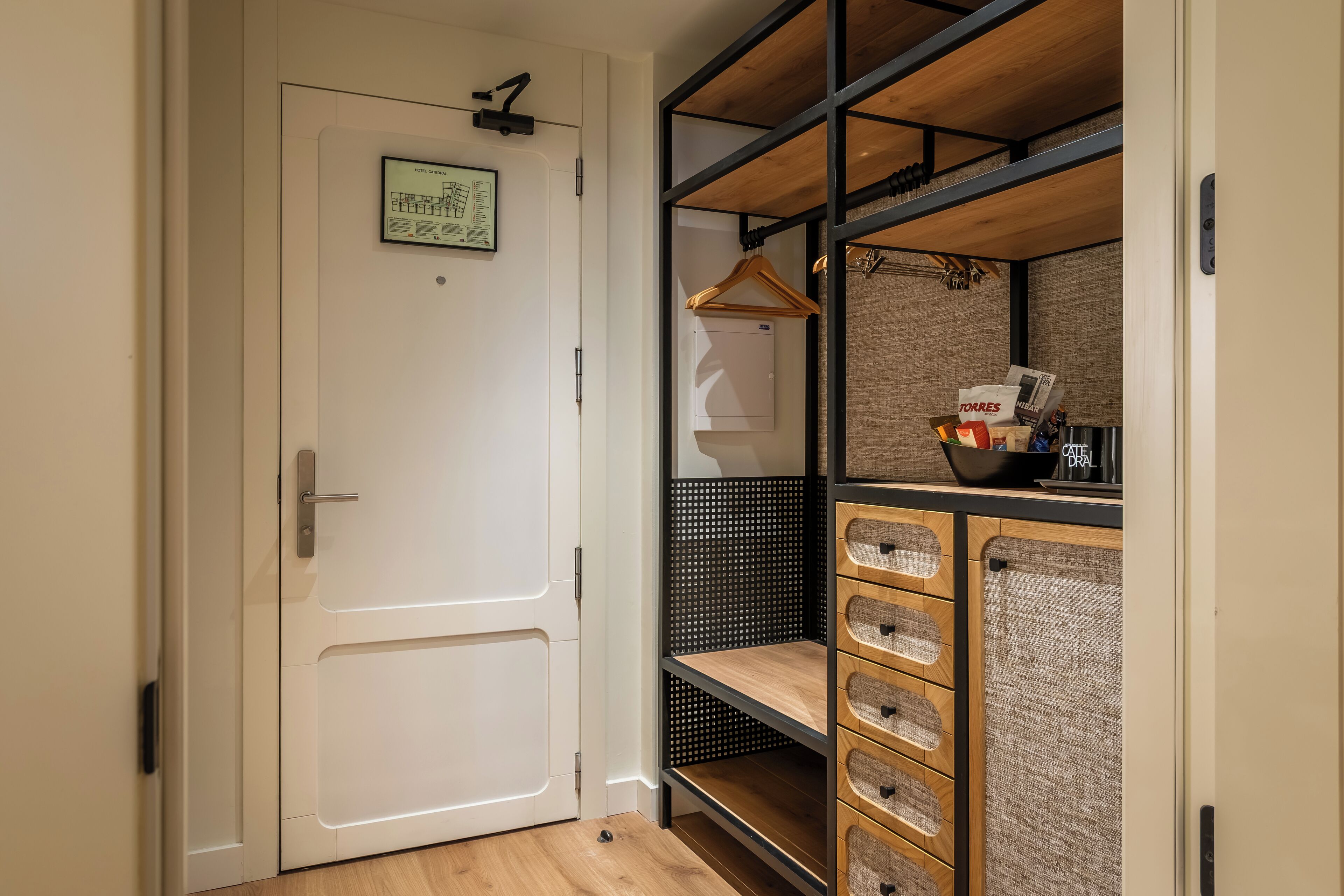 A walk-in closet with a white door, a hanging rack, and a shelving unit with baskets.