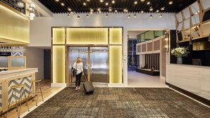 A modern hotel lobby with a reception desk, bar area, and elevator. - Hotel Barcelona Catedral (Barcelona)