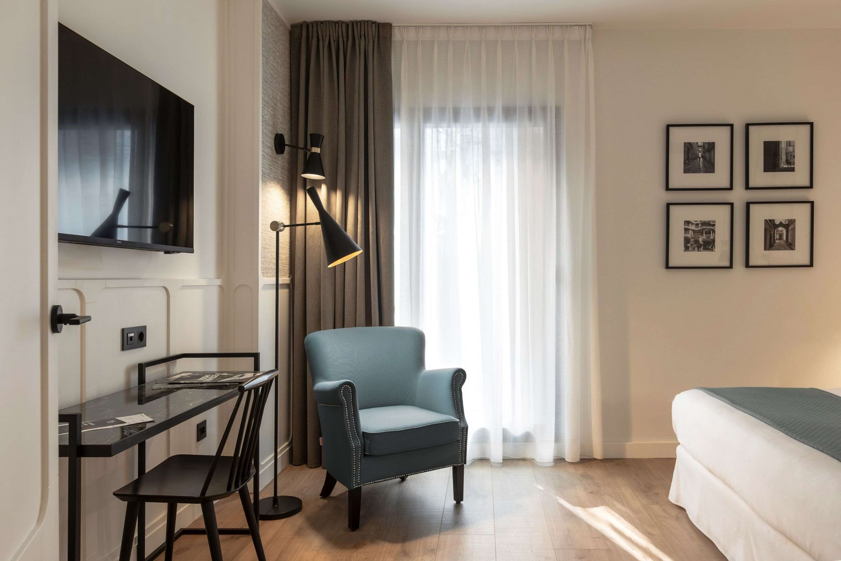Una habitación de hotel moderna con escritorio, silla y cama.