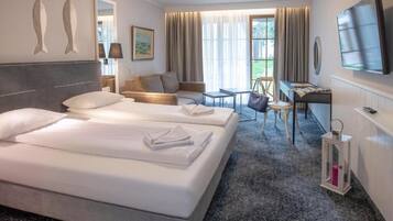 Une chambre d’hôtel avec deux lits, un bureau, une chaise, une télévision et une fenêtre avec des rideaux.