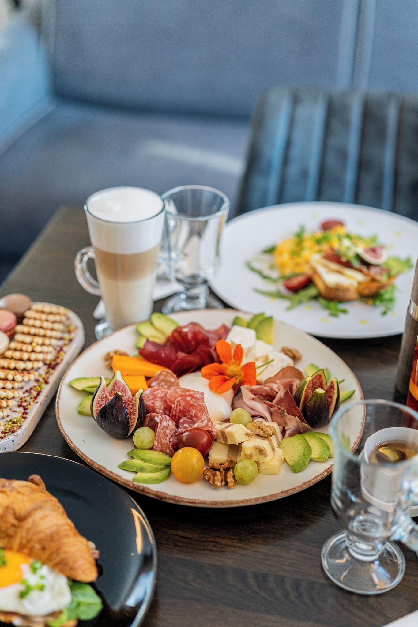Una mesa con platos de comida, una taza de café y un vaso de agua.