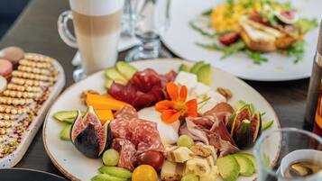 Una mesa con platos de comida, una taza de café y un vaso de agua.
