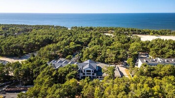 A coastal resort with dense forest, a beach, and multiple buildings.