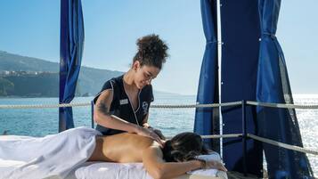Experience a soothing massage on our seaside platform, overlooking the ocean and distant hills.