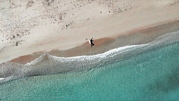 Vista aérea de una playa con una persona practicando surf.