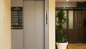 Een hotel receptie met een verticale informatieborden waarop kamer nummers en de bijbehorende verdiepingen staan vermeld.