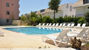 Piscine extérieure, parasols de plage, chaises longues