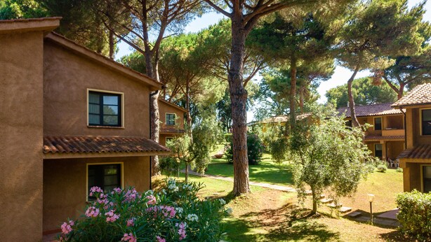 A building with a stucco exterior, multiple windows, and a tiled roof. - Residence Il Paradiso (Guardistallo)