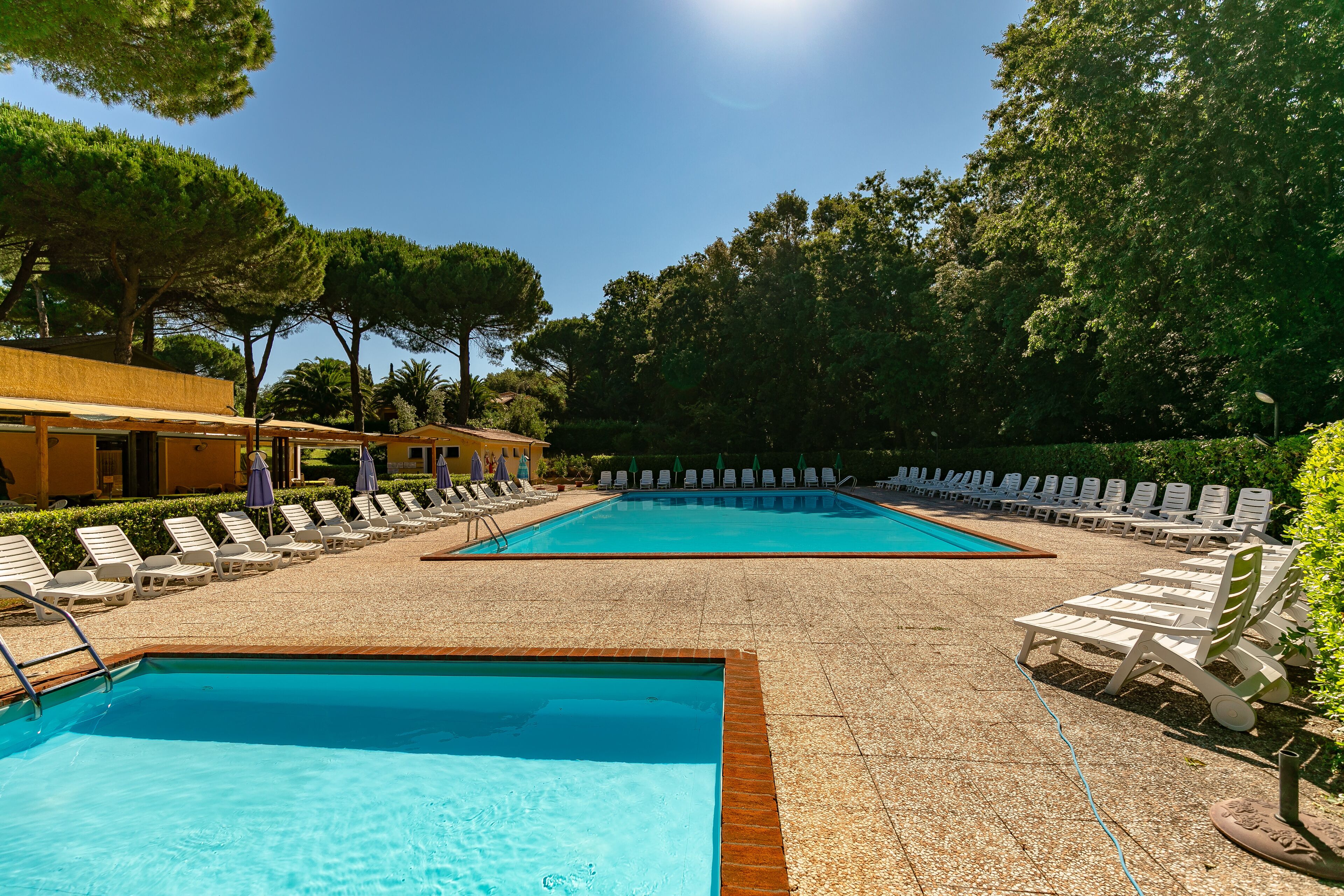 Una piscina al aire libre de temporada, sombrillas