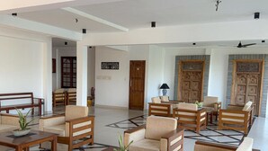 A spacious lobby with wooden furniture, a checkered floor, and a large door in the background. - Serendib Beach Resort (Induruwa)