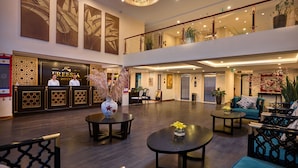 A hotel lobby with a reception desk, seating area, and a chandelier. - Freesia Hotel (Sa Pa)