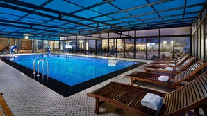 A swimming pool with lounge chairs and a covered area. - Freesia Hotel (Sa Pa)