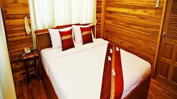 A wooden-paneled room with a bed, a nightstand, and a telephone.