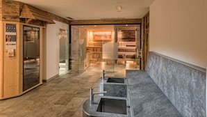 Un vestíbul d'hotel modern amb un taulell de recepció de fusta, una paret de vidre i un mostrador de marbre amb rentabancs.