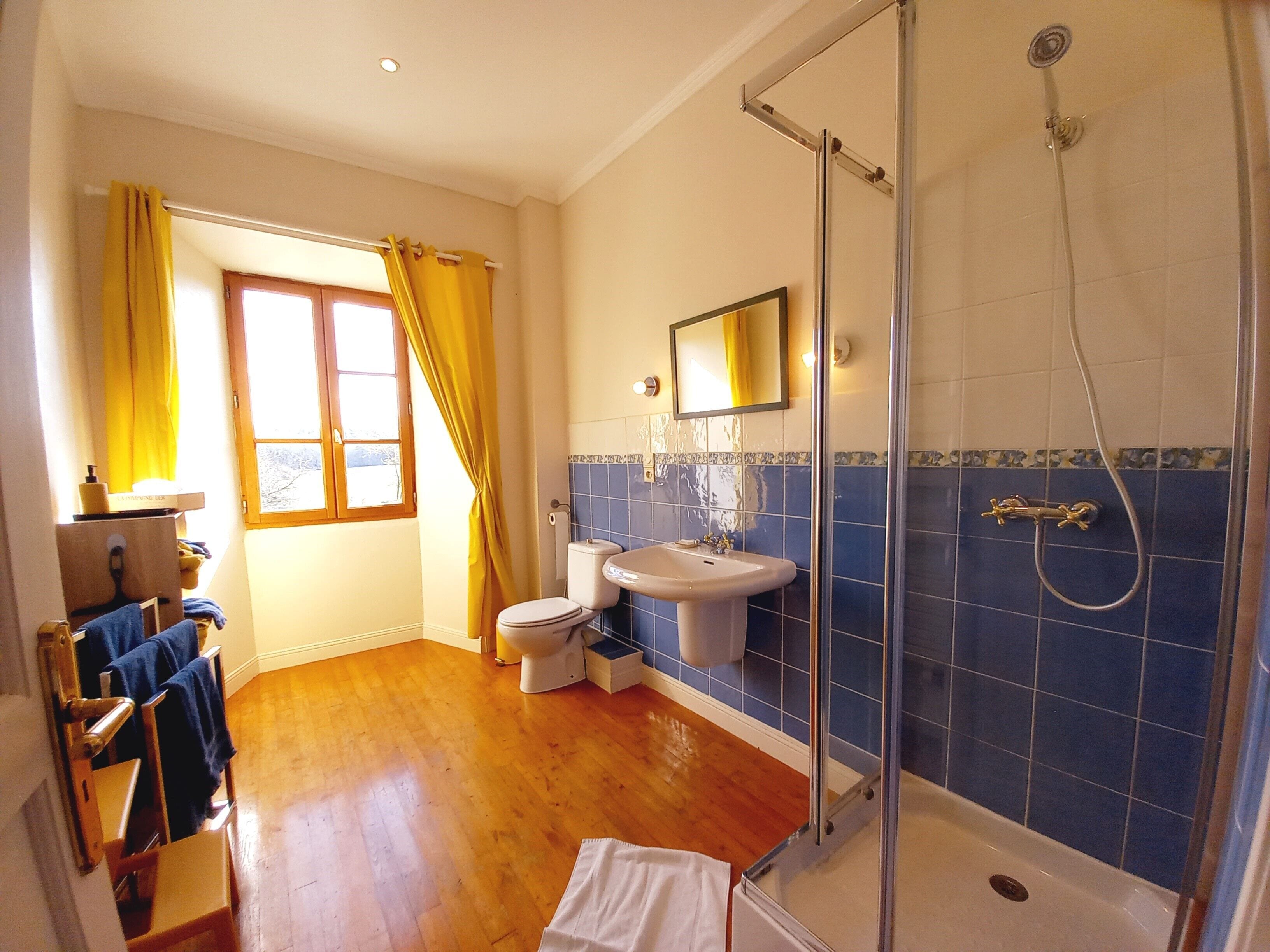 A bathroom with a shower, toilet, and sink.