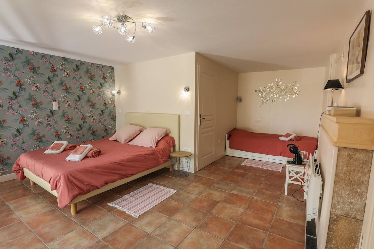 Une chambre à coucher comprenant un lit, une table de chevet, une lampe et un élément décoratif fixé au mur.