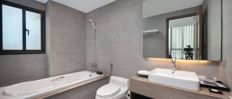 A modern bathroom with a bathtub, toilet, and sink.