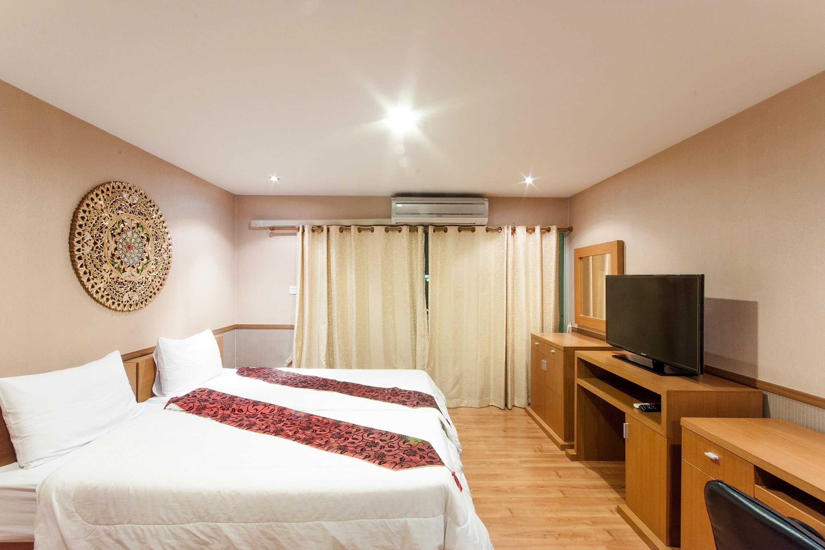 Une chambre d’hôtel avec deux lits, une télévision, un bureau et un appareil de climatisation.