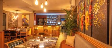 A restaurant with a dining area, bar, and kitchen.