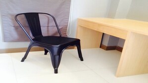 A room with a black chair, a wooden desk, and a white tiled floor. - The Sixnature Resort Bangsaen (Chonburi)