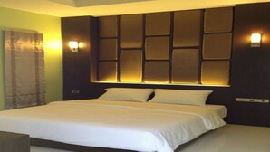 A modern hotel room with a large bed, a headboard with illuminated panels, and two wall-mounted lights. - The Sixnature Resort Bangsaen (Chonburi)