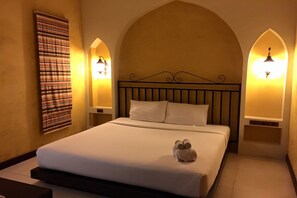 Ein Hotelzimmer mit einem großen Bett, zwei Nachttischlampen und einer dekorativen Wandverkleidung.