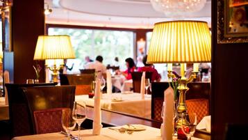 Ein Restaurant mit gedeckten Tischen, Lampen und Kerzen.