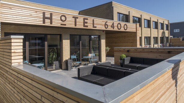 A hotel with a modern design, featuring a wooden facade and a sign that reads "HOTEL 6400". - Hotel 6400 (Sønderborg)
