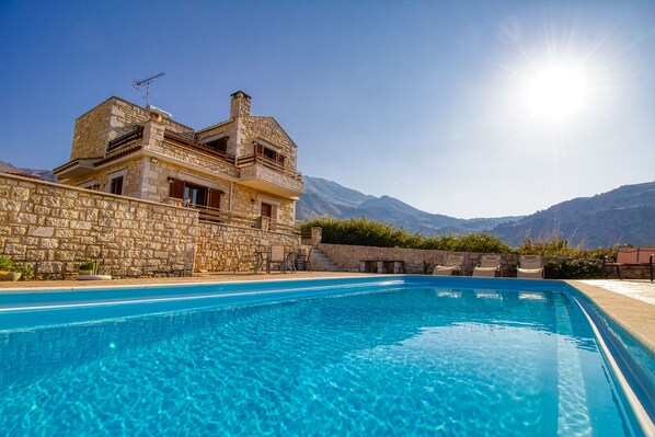Una piscina techada, una piscina al aire libre, sombrillas