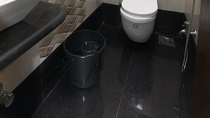 Un baño con lavamanos, inodoro, ducha y toallero.