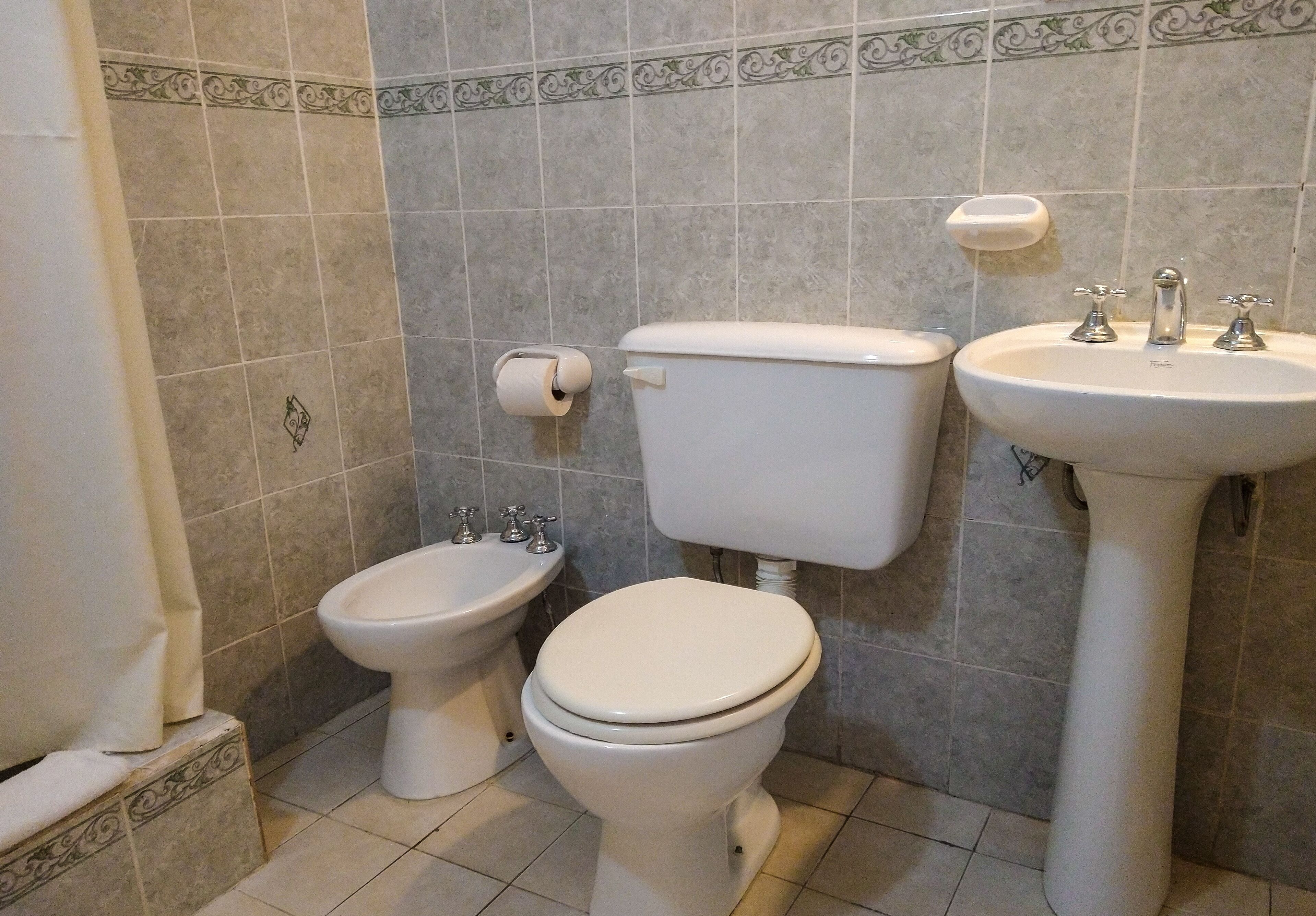 A bathroom with a toilet, bidet, and sink.