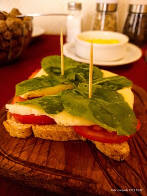 A sandwich with spinach and tomato on a wooden board. - Hotel de la Linda (Salta)