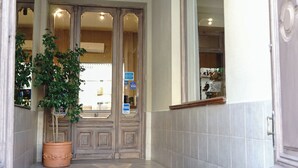 Una escalera que lleva a una puerta, con una planta en maceta a su lado.