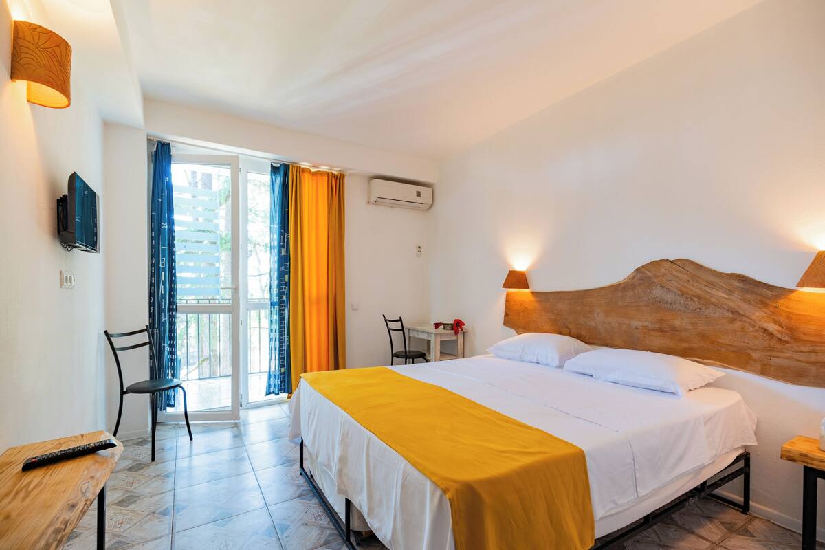 Ein Hotelzimmer mit Bett, Schreibtisch, Stuhl und Fernseher.