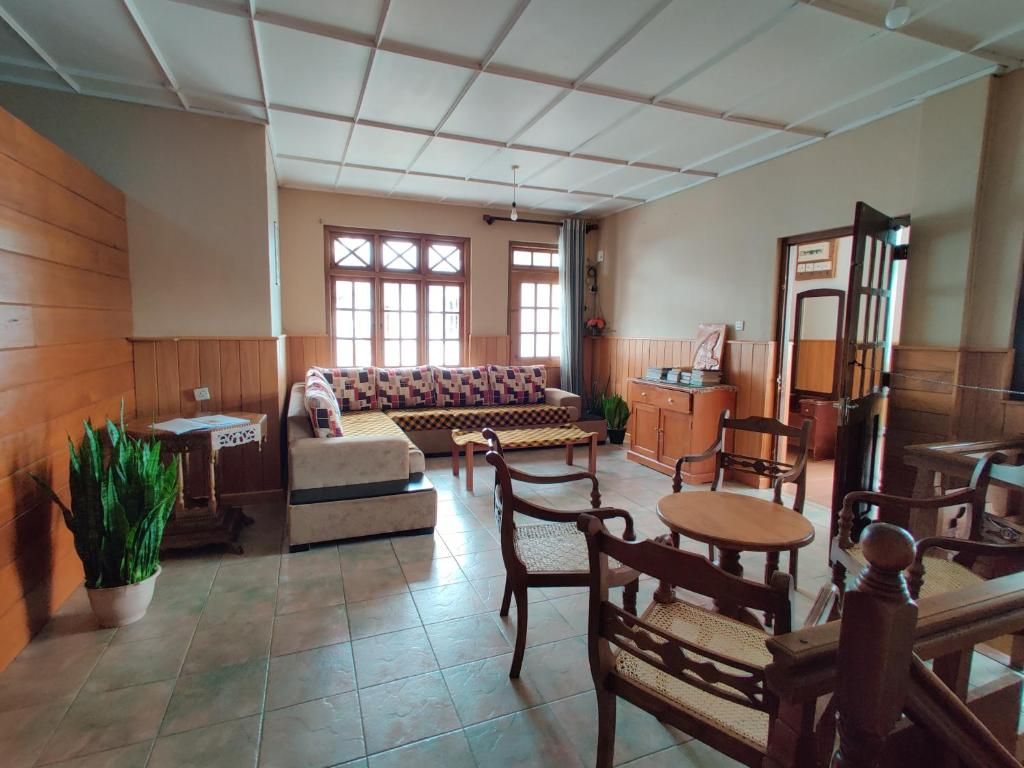 A room with a sofa, chairs, a table, and a cabinet.
