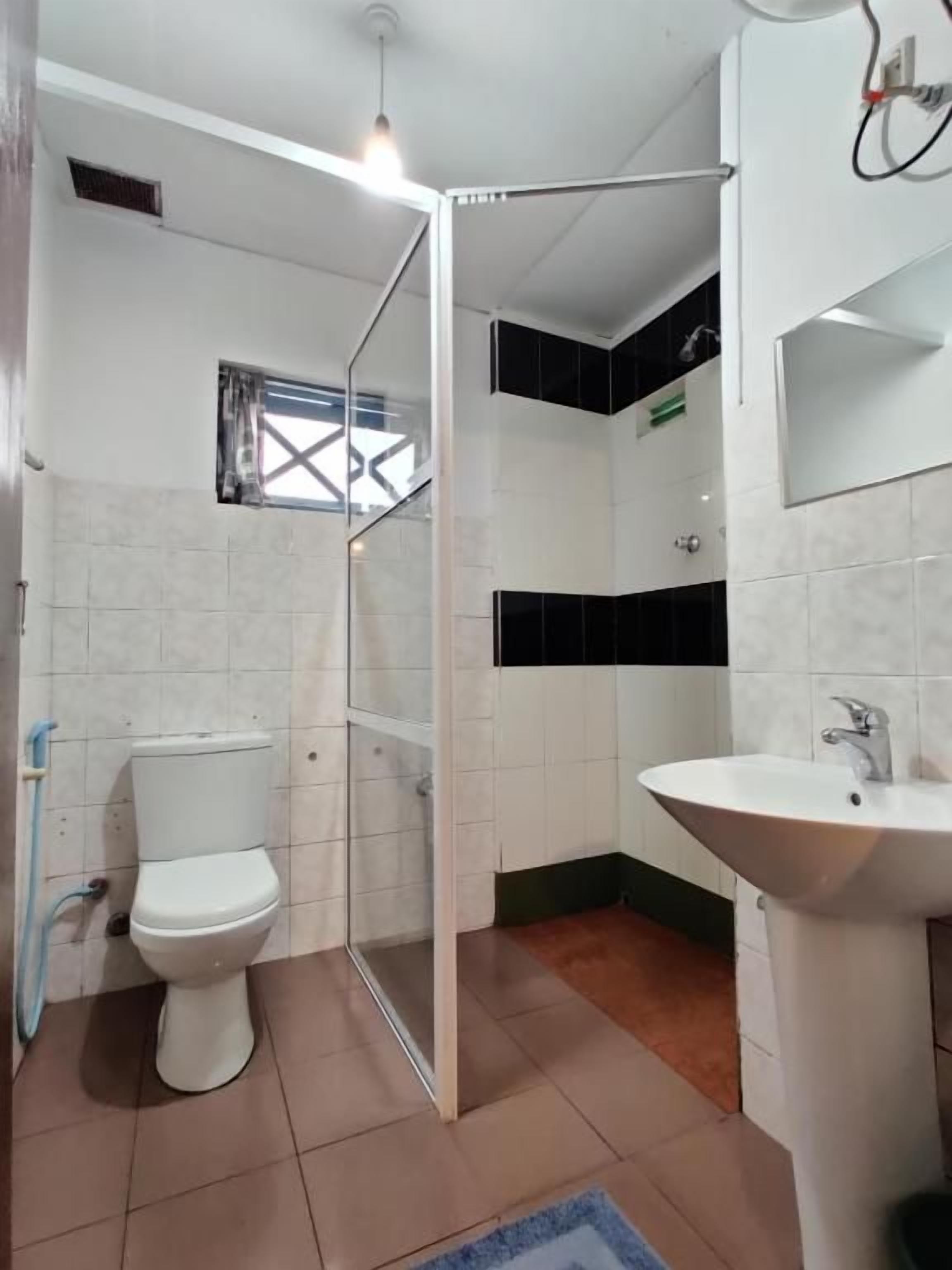 Un baño con inodoro, ducha y lavamanos.