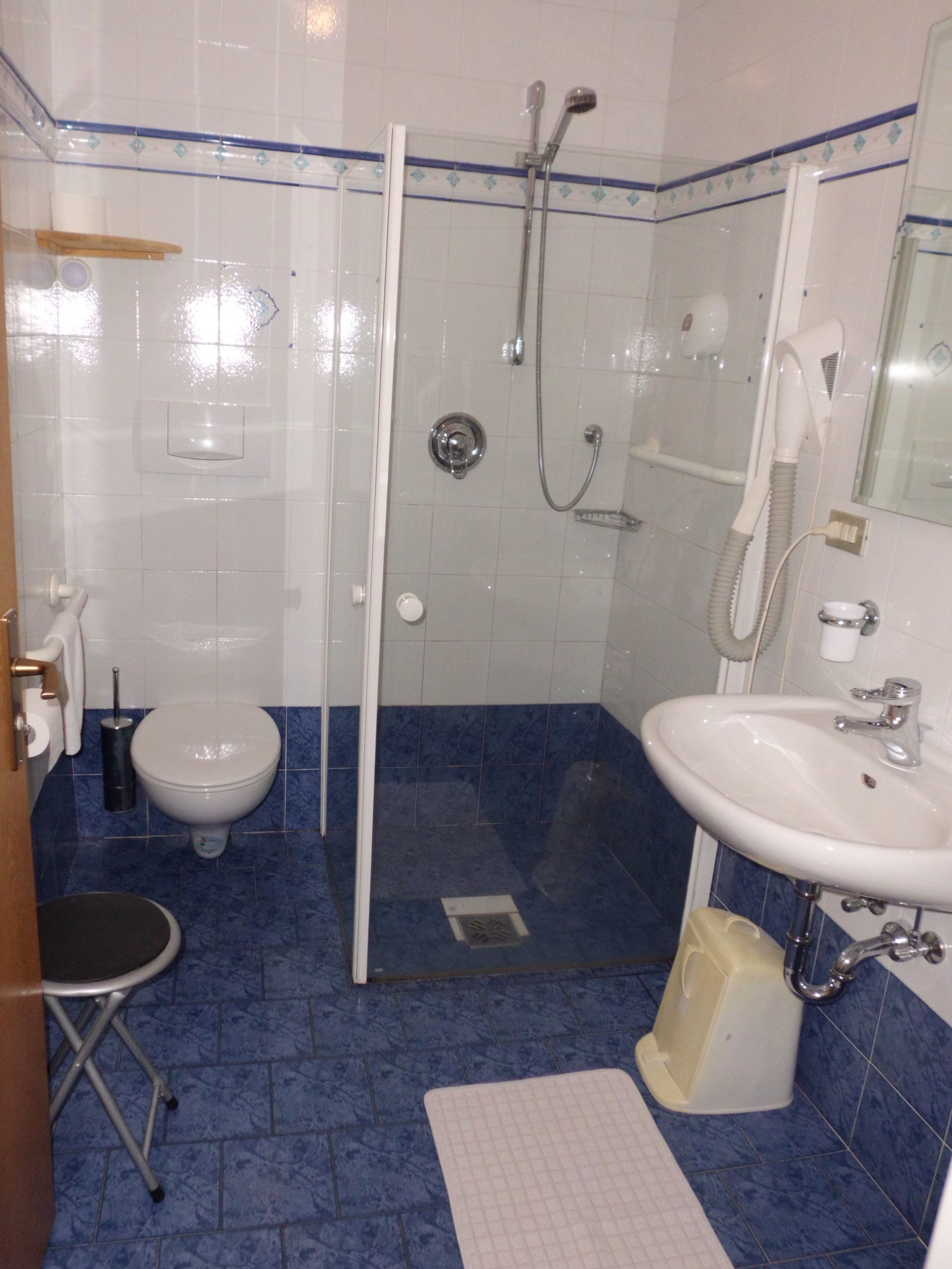 Un baño con ducha, inodoro y lavabo.