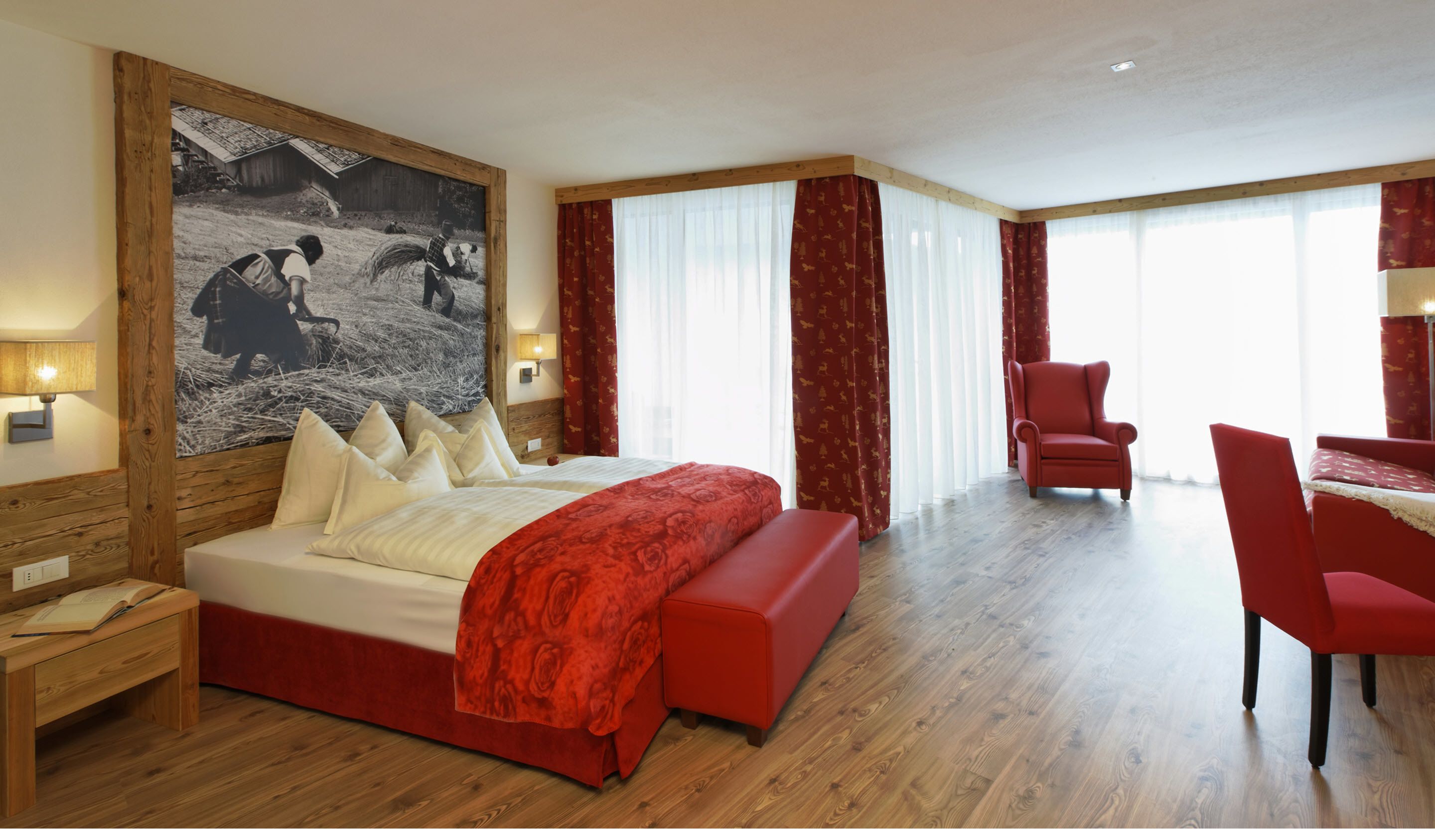 Ein Hotelzimmer mit einem großen Bett, einem Schreibtisch, einem Sessel und einem Bild an der Wand.