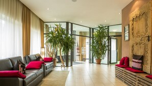 Una sala de estar moderna con un juego de sofá, un banco de madera y plantas en macetas.