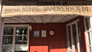 A wooden reception sign with "RECEPTION" and "WELCOME PÅ RØNNEVANDRERHJEM" written on it.