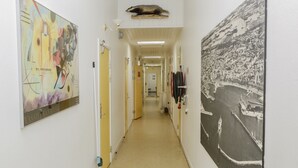 Un couloir orné d’œuvres d’art sur les murs et les portes, ainsi que d’une grande fresque murale.