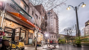 A hotel with a visible storefront, outdoor seating, and a parked vehicle. - Avital Hotel (Jerusalem)
