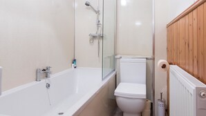 A bathroom with a bathtub, toilet, and shower. - Blair Drummond Holiday Home (Doune)