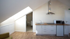A compact kitchen with a skylight, a microwave, and a dishwasher. - Sui7es Guest House Cascais (Cascais)