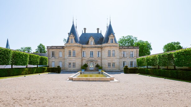 A large, historic building with a symmetrical facade, a central entrance, and a courtyard with a fountain. - Chambre D'hôtes Château de Lussac (Lussac)
