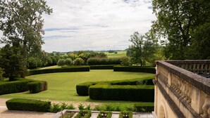 A formal garden with neatly trimmed hedges and a gravel path. - Chambre D'hôtes Château de Lussac (Lussac)