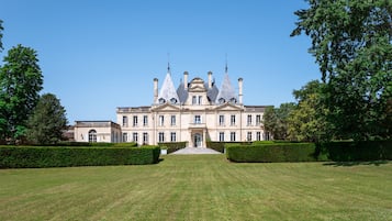 Experience the grandeur of this historic building, featuring a symmetrical facade with gabled roofs and a central entrance.