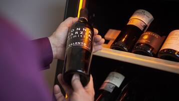 Una persona sosteniendo una botella de vino con la etiqueta que dice "ONNAAIARZIMITIVO SALENTO".